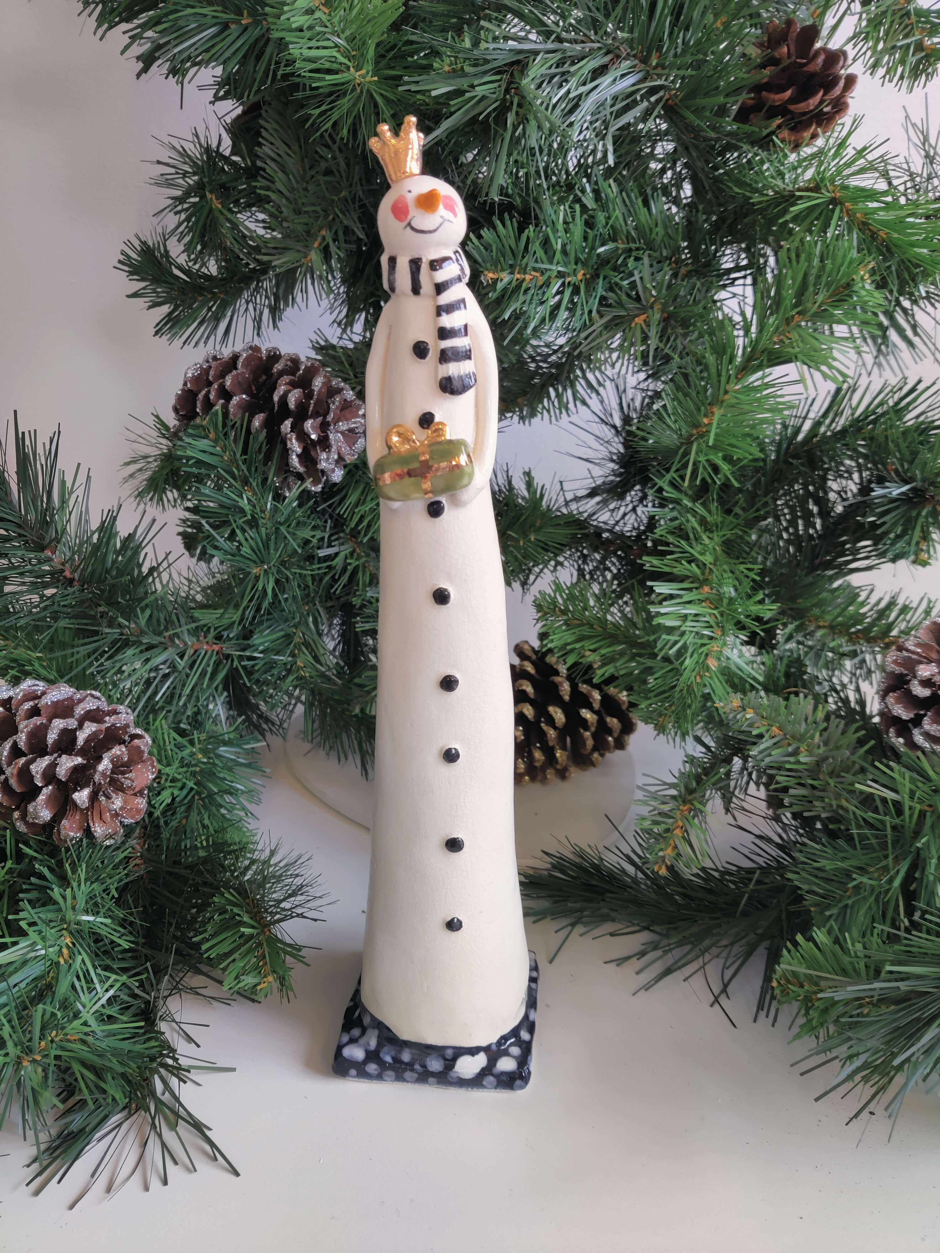 Joanne Robey, Snowman Black Stripe Scarf holding a Green Gift *For Click and Collect only*